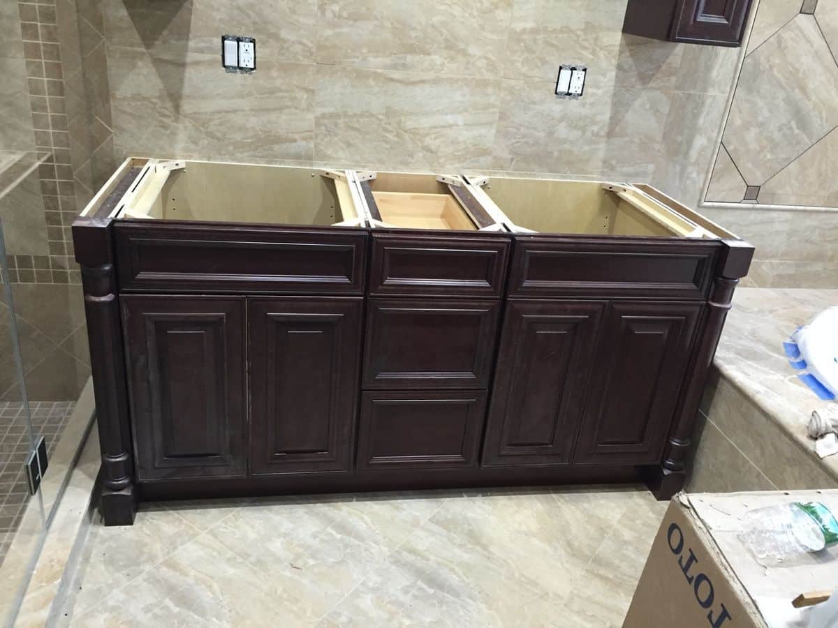 Custom cherry double vanity cabinets installed against finished tile in a Mt. Washington master bathroom